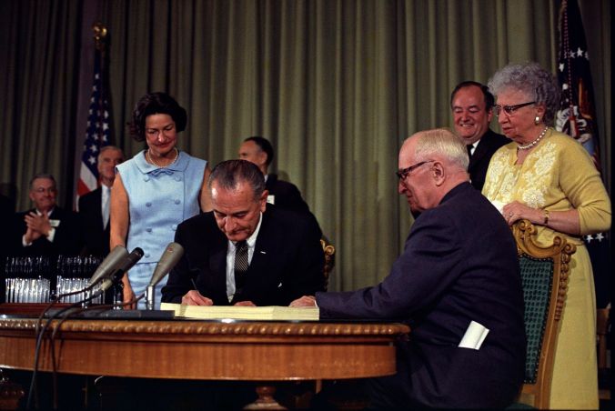 1600px-Lyndon_Johnson_signing_Medicare_bill,_with_Harry_Truman,_July_30,_1965